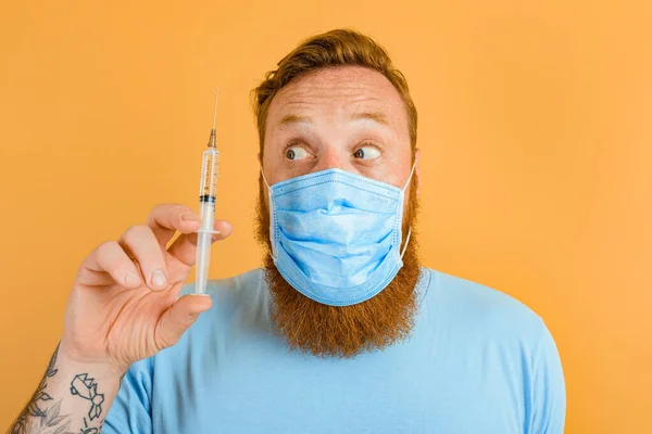 Дивовижний чоловік з бородою, татуюванням та маскою для ковадла-19 готовий до вакцини проти вірусу — стокове фото