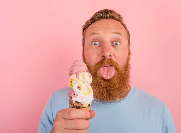 Homme avec barbe et tatouages mange une grosse glace — Photo