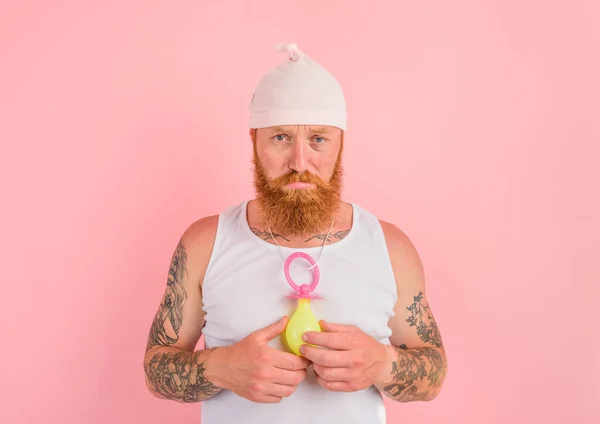 Waanzin man met baard en tatoeages gedraagt zich als een kleine pasgeborene — Stockfoto