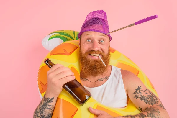 Glücklicher Mann ist bereit, mit einem Donut Lebensretter mit Bier und Zigarette zu schwimmen — Stockfoto