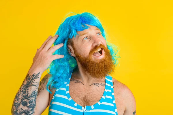 Uomo felice con boa di salvataggio, costume da bagno e parrucca blu si comporta come una donna felice — Foto Stock