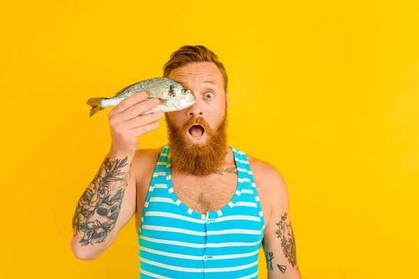 Uomo con barba e costume da bagno catturato un pesce — Foto Stock