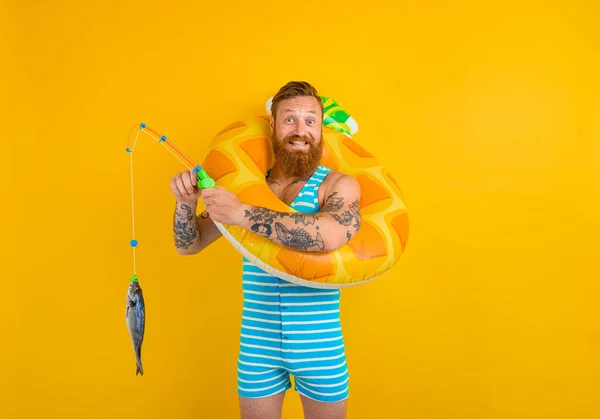 Homme heureux avec barbe et beigne gonflable attrape le poisson — Photo