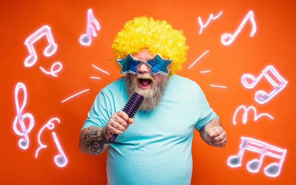 Dikke man met baard, tatoeages en zonnebril zingt een lied — Stockfoto
