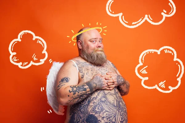 Dikke man met baard, tatoeages en vleugels gedraagt zich als een engel — Stockfoto