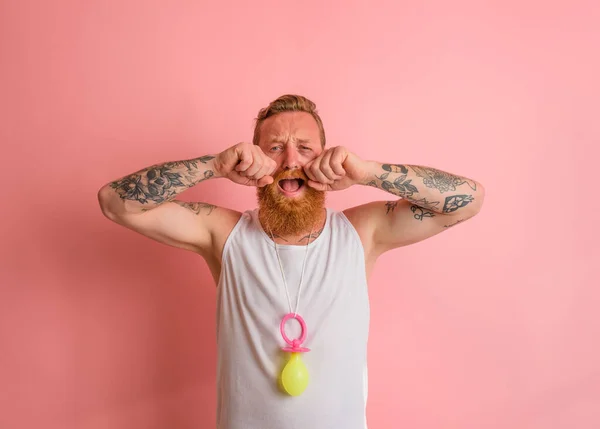 Gridare uomo con la barba e tatuaggi si comporta come un piccolo neonato — Foto Stock