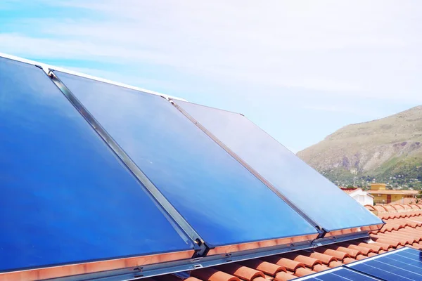 Elektrik ve sıcak su için güneş paneli olan yenilenebilir enerji sistemi — Stok fotoğraf
