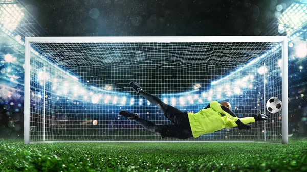 Futbol kalecisi, floresan üniformalı, harika bir kurtarış yapıyor ve stadyumdaki maçta gol atmaktan kaçınıyor.