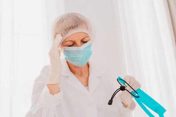 Arzt mit Mundschutz und Gesichtsschutz ist müde von der Covid-19-Virus-Pandemie — Stockfoto