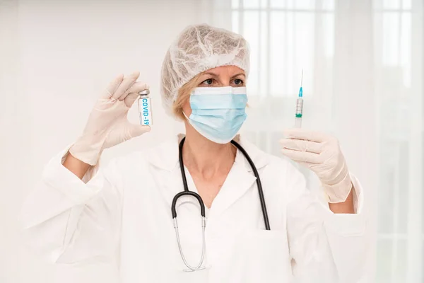 El médico con mascarilla y jeringa está listo para administrar la vacuna contra covid-19 —  Fotos de Stock