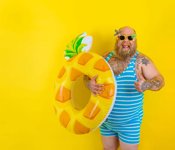 Gros homme heureux avec une perruque à la tête est prêt à nager avec un sauveteur de beigne — Photo
