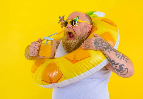Gros affamé homme avec une perruque à la tête est prêt à nager avec un sauveteur de beigne — Photo