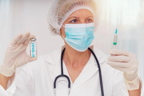 Лікар з маскою і шприцом готовий вводити вакцину проти ковадла 19 — стокове фото