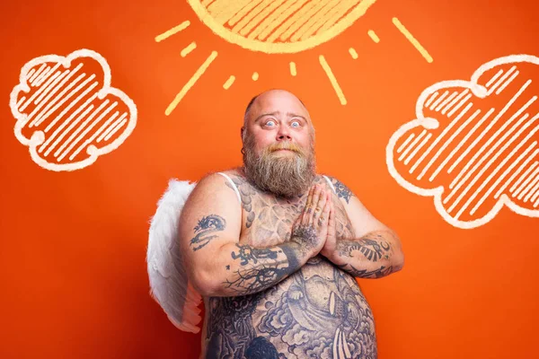 Dikke man met baard, tatoeages en vleugels gedraagt zich als een engel — Stockfoto