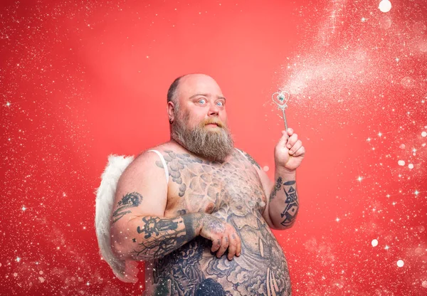 Dikke attente man met baard, tatoeages en vleugels gedraagt zich als een magische fee — Stockfoto