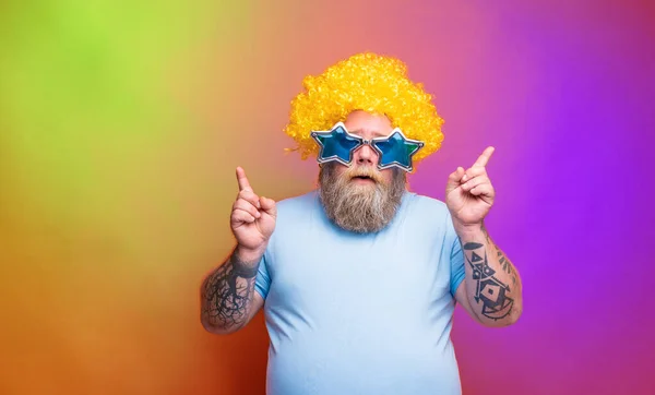 Gros homme réfléchi avec barbe, tatouages et lunettes de soleil danse la musique sur une discothèque — Photo