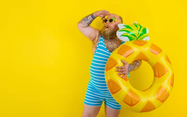 Gros homme étonné avec une perruque à la tête est prêt à nager avec un sauveteur de donut — Photo