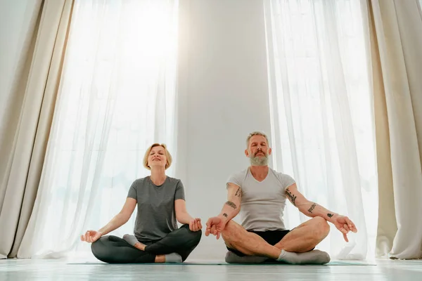 Esposo y esposa hacen ejercicio de yoga juntos en casa —  Fotos de Stock