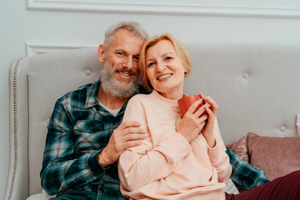 муж и жена завтракают с кофе на кровати дома