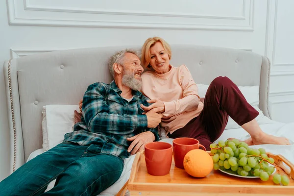 Чоловік і дружина поснідали на ліжку з кавою і фруктами — стокове фото