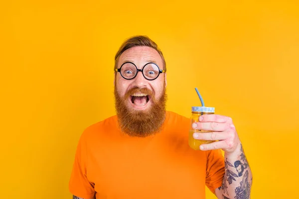Nerd uomo felice con bicchieri beve un succo di frutta — Foto Stock