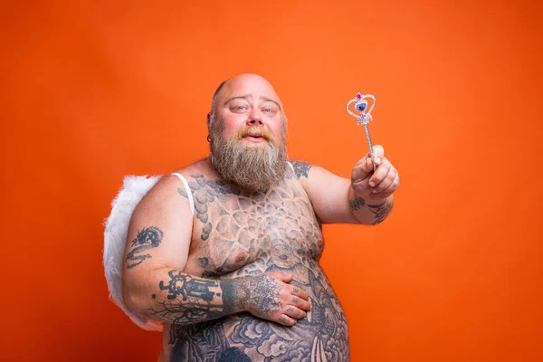 Gordo hombre feliz con barba, tatuajes y alas actúa como un hada mágica — Foto de Stock
