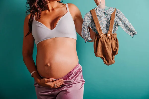 Těhotná maminka připravuje oblečení pro dítě — Stock fotografie