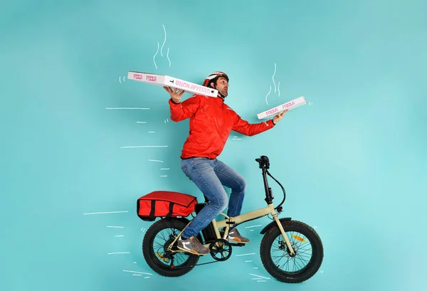 Deliveryman runs fast with electric bike to deliver pizza — Stock Photo, Image