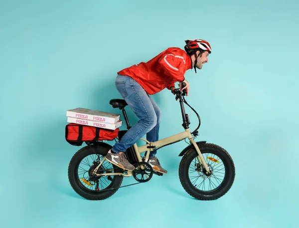 Deliveryman runs fast with electric bike to deliver pizza — Stock Photo, Image