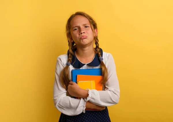 Το κορίτσι κλαίει επειδή έχει πολλή σχολική εργασία. Συναισθηματική έκφραση. Κίτρινο φόντο — Φωτογραφία Αρχείου