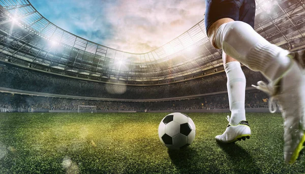 Stadyumdaki futbol sahnesinde bir futbol ayakkabısının topa vuruşu.