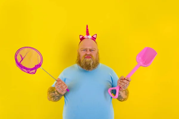 Fat man with headband play with sea net and paddle — Stock Photo, Image