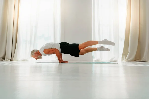 Hombre deportivo hace ejercicio de yoga en casa — Foto de Stock
