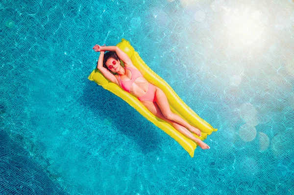 Menina em maiô que bronzear em uma piscina — Fotografia de Stock