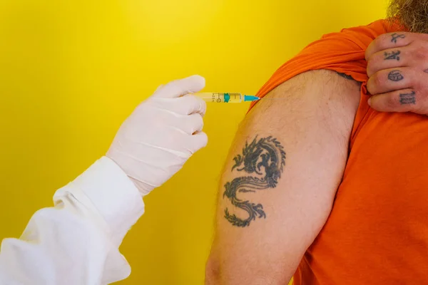 Чоловік з бородою та татуюваннями робить вакцину проти ковідо-19 — стокове фото