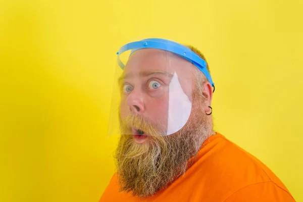 Uomo stupito con barba e tatuaggi indossa uno scudo facciale protettivo contro covid-19 — Foto Stock