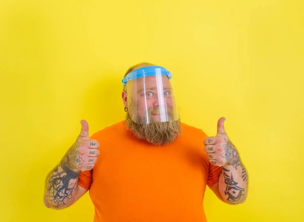 Szczęśliwy człowiek z brodą i tatuażami nosi ochronną osłonę twarzy przed covid-19 — Zdjęcie stockowe
