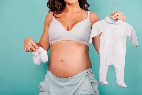 Mãe grávida prepara as roupas para o bebê — Fotografia de Stock