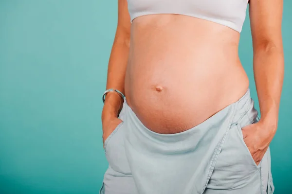 Mulher grávida esperando uma criança acaricia sua barriga — Fotografia de Stock