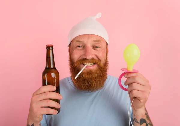 Uomo felice con la barba e tatuaggi si comporta come un bambino appena nato con la birra in mano — Foto Stock