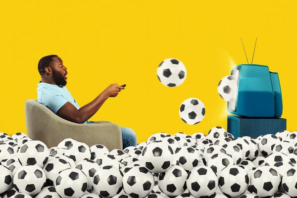 Espectador de fútbol sorprendido sumergido por pelotas de fútbol que salen de la televisión —  Fotos de Stock
