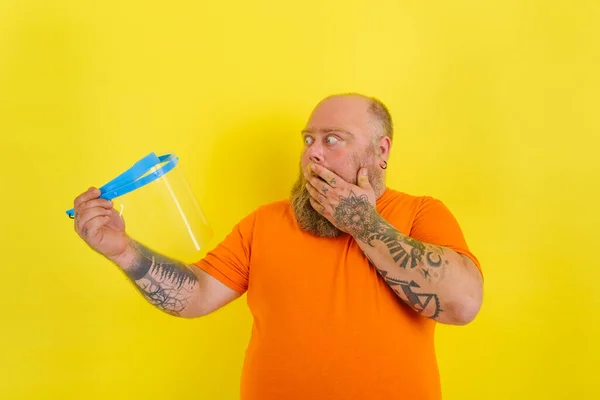 Verbazingwekkende man met baard en tatoeages maakt zich zorgen over een beschermend gezichtsschild tegen covid-19 — Stockfoto