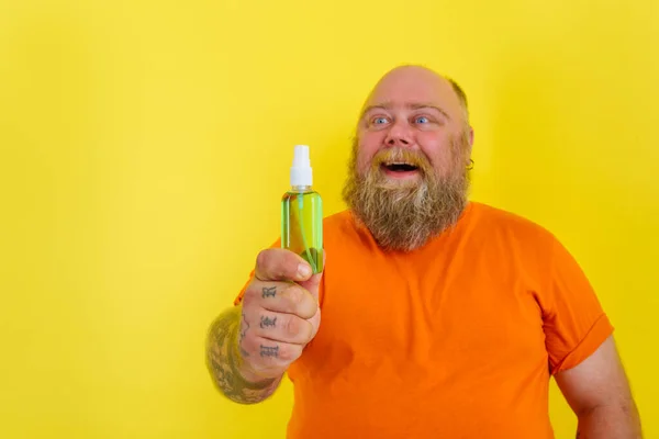 Hombre feliz con barba y tatuajes sostiene un limpiador de manos contra covid19 — Foto de Stock