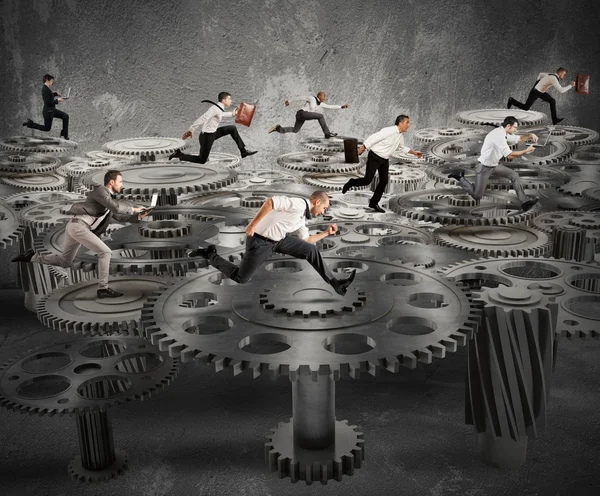 Business people running over mechanism — Stock Photo, Image