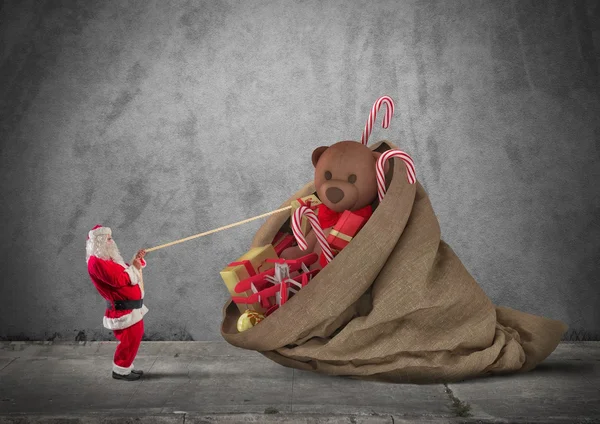 Санта тягне мішок подарунків — стокове фото