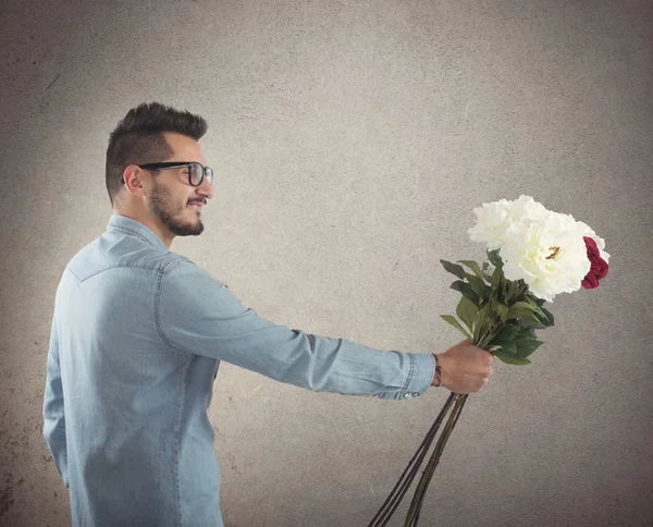 Nerd boy gives flowers — Stock Photo, Image