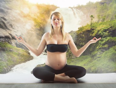 Hamile kadın yoga yapıyor.