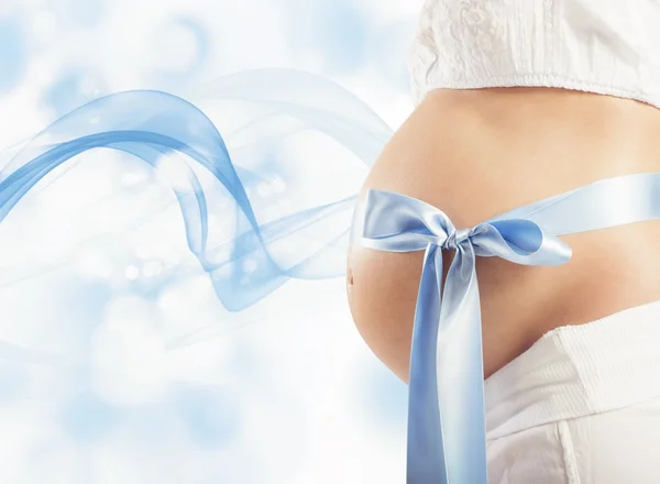 Беременная женщина с голубым луком — стоковое фото