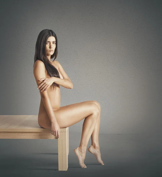 Nakenmodell sitter på bord — Stockfoto