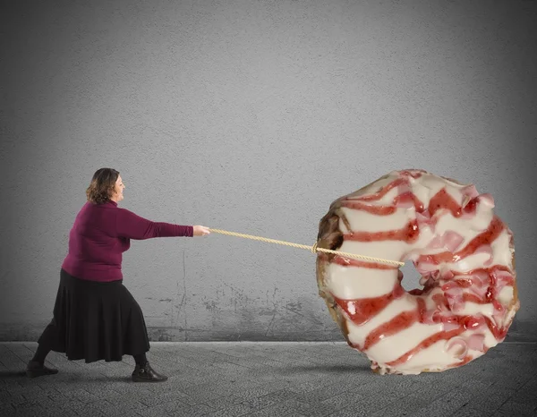 Толстая женщина тянет пончик — стоковое фото